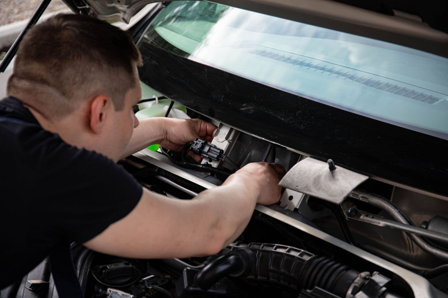 Tekniker arbetar i motorrummet på en bil